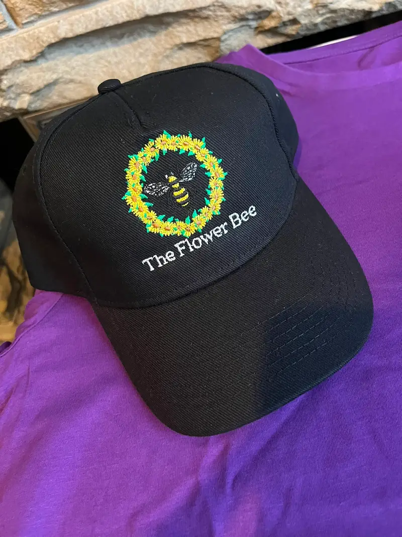 Black cap embroidered with The Flower Bee bee and sunflower wreath logo