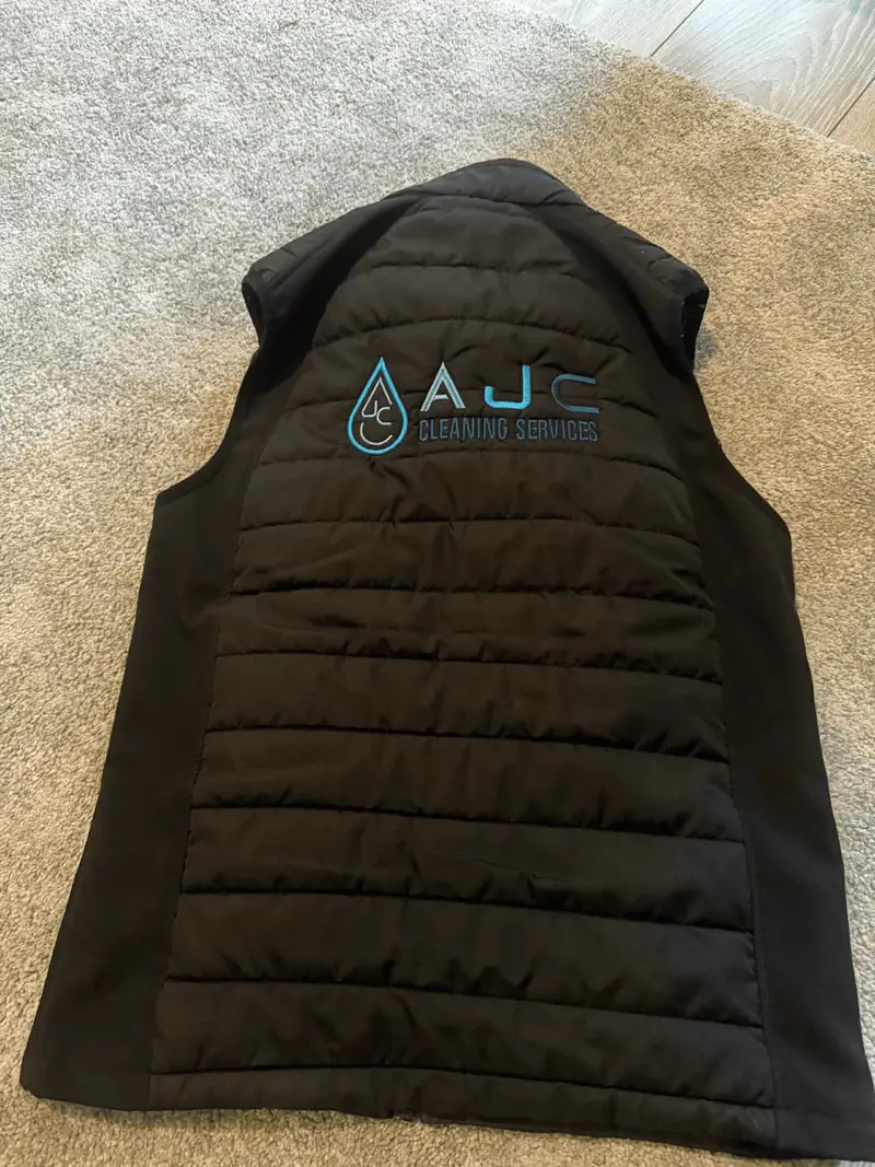 Black gilet embroidered with the AJC Cleaning Services logo