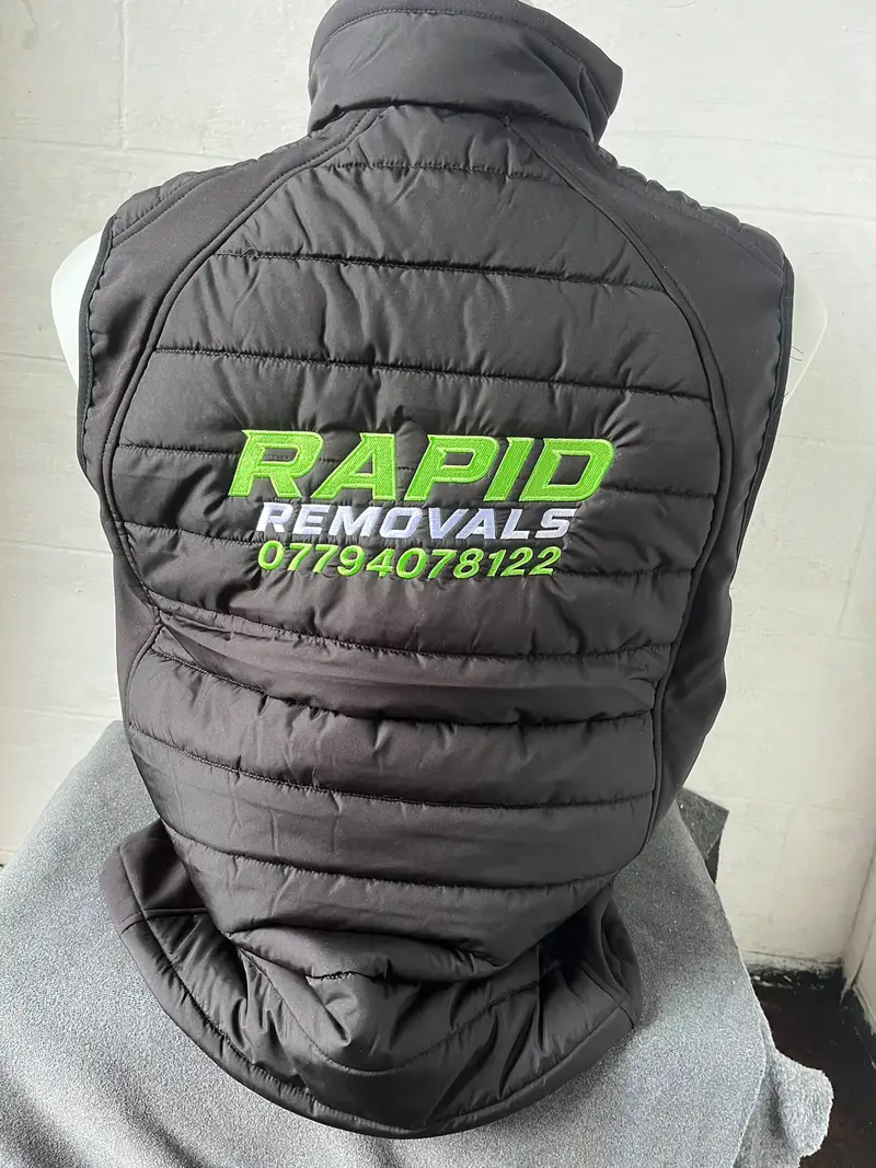 Black gilet with large Rapid Removals lettering and phone number on the back