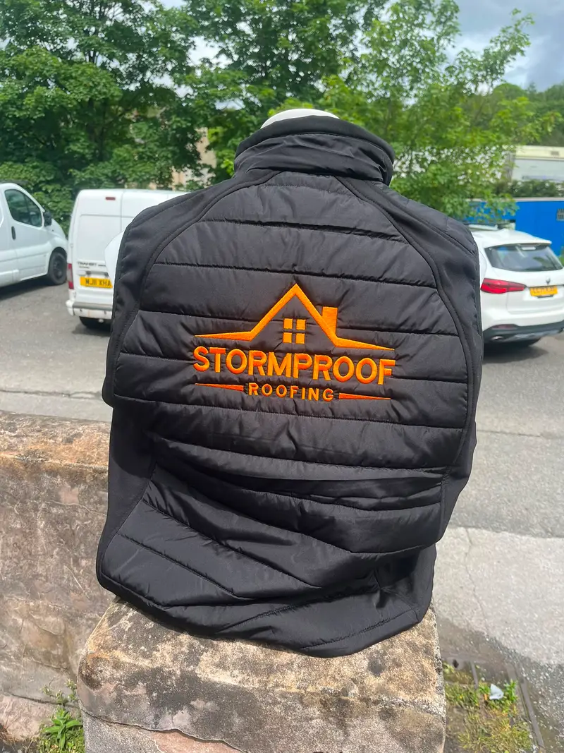 Black gilet worn back to camera, with the Stormproof Roofing logo embroidered large across the back