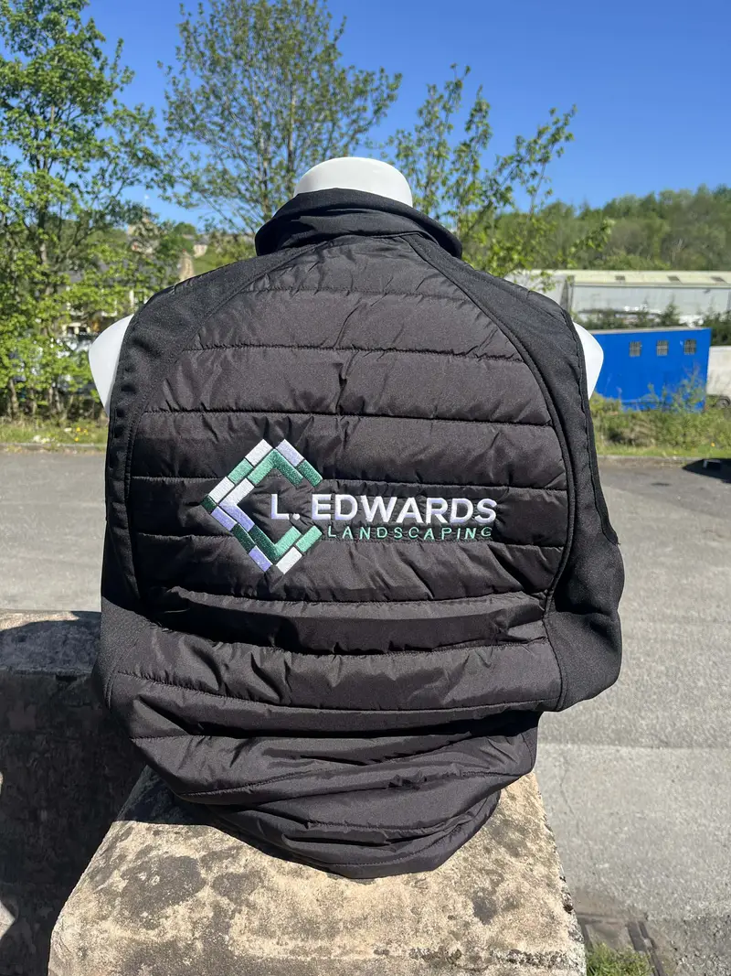 Black gilet worn back to camera, embroidered with the L. Edwards Landscaping logo