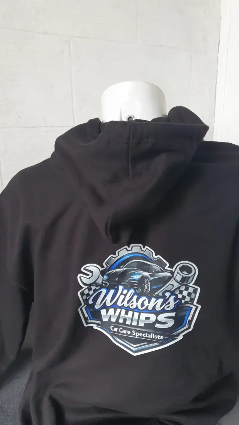 Black hoodie printed with the full-colour Wilson's Whips car care shield on the back