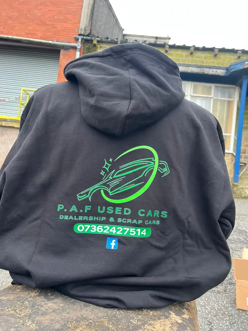Black hoodie worn back to camera, printed with the P.A.F Used Cars logo and contact details