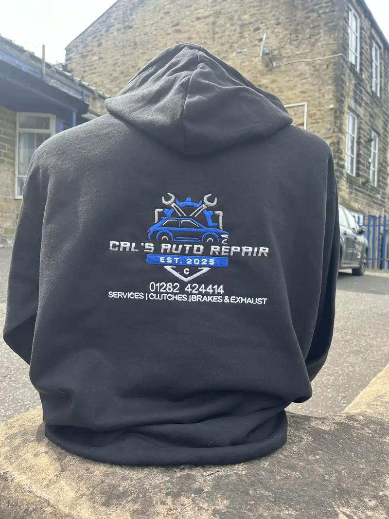 Black hoodie worn back to camera, embroidered with the Cal's Auto Repair logo and phone number