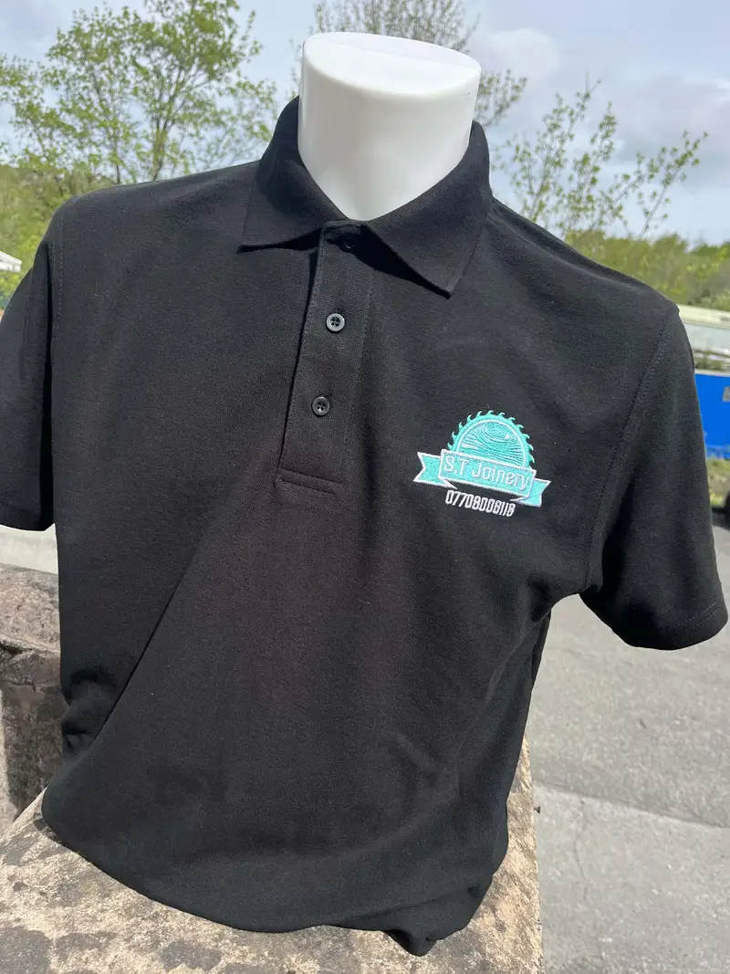 Black polo shirt embroidered with the S.T Joinery logo