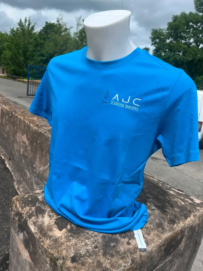 Blue AJC Cleaning Services t-shirt on a mannequin outdoors