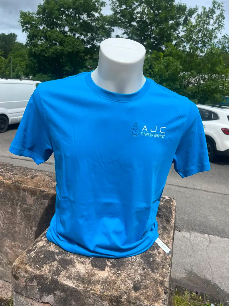 Bright blue work t-shirt embroidered with the AJC Cleaning Services logo on the left chest