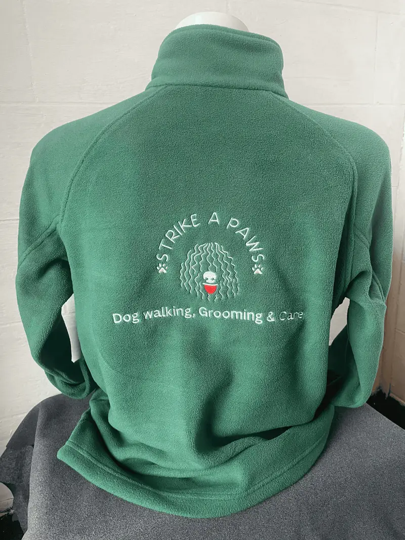 Green fleece embroidered in Colne for Strike A Paws dog walking, grooming and care