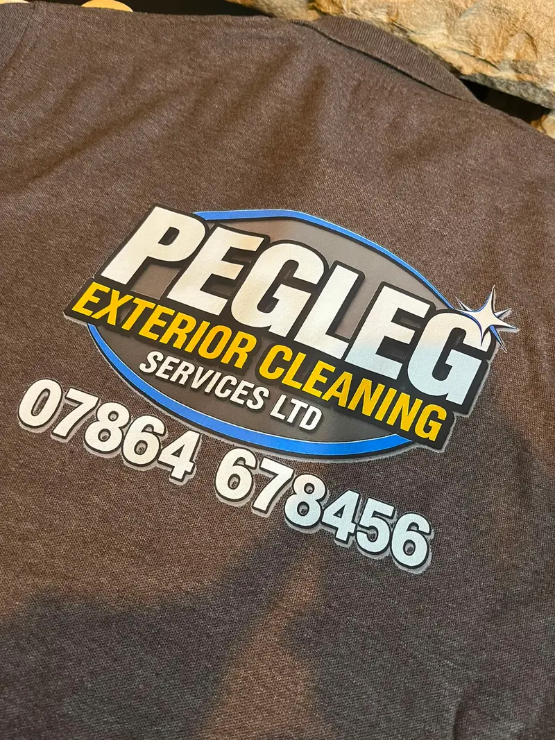 Grey t-shirt printed with the Pegleg Exterior Cleaning logo and contact number across the back