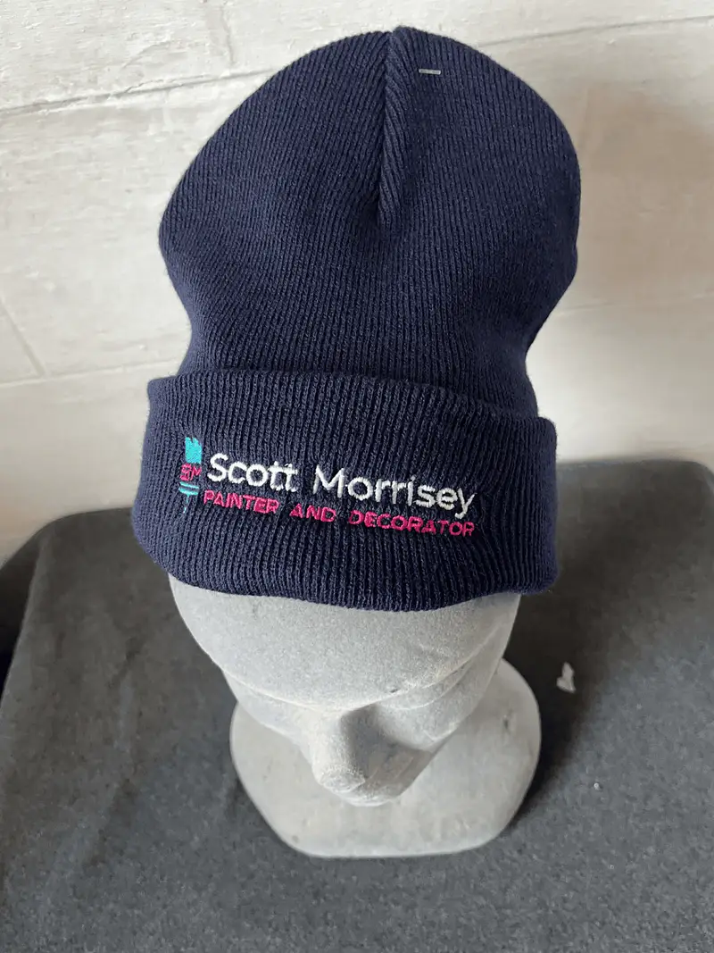 Navy beanie embroidered with the Scott Morrisey painter and decorator logo