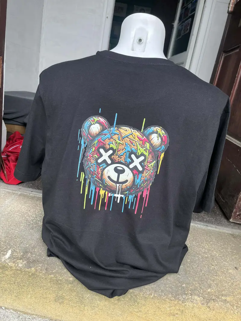 Oversized black t-shirt printed with a full-colour graffiti bear design across the back