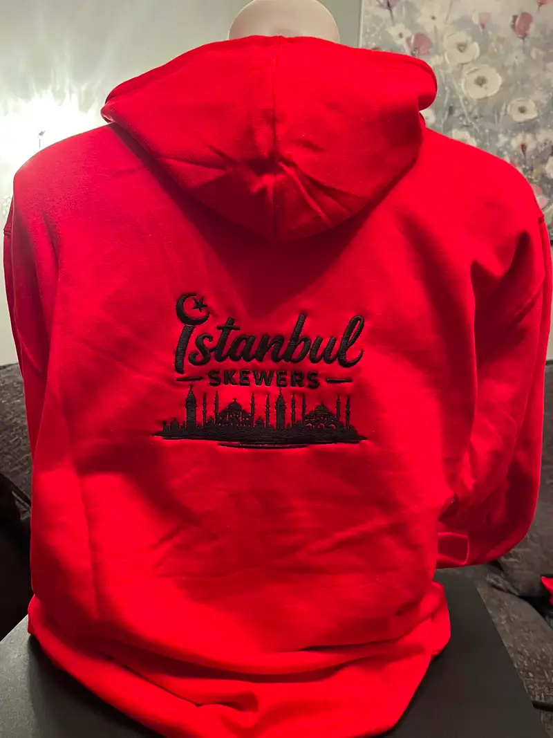 Red hoodie embroidered with the Istanbul Skewers logo and skyline