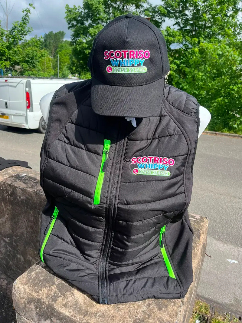 Scotriso Whippy branded cap and gilet on a stone wall