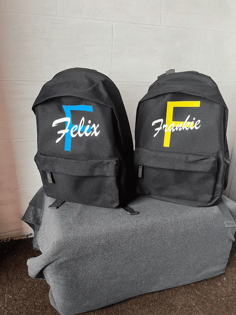 Two black backpacks personalised with the names Felix and Frankie